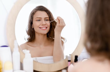 femme qui met de l'huile sèche sur son visage