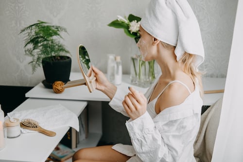 Jeune femme assise en train de faire ses soins du visage