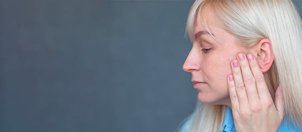 Femme examinant la peau de son visage.