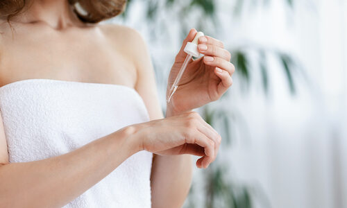 femme qui applique de l'huile sèche