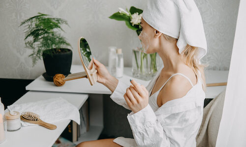 Jeune femme assise en train de faire ses soins du visage